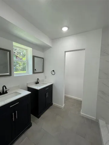 a view of bathroom with a sink and mirror