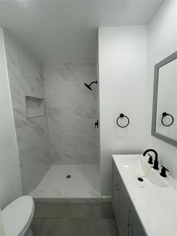 a bathroom with 2 sink toilet and mirror