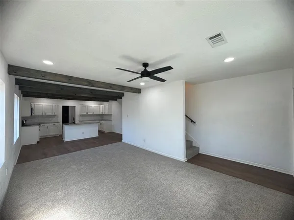 a view of a livingroom with a ceiling fan and window