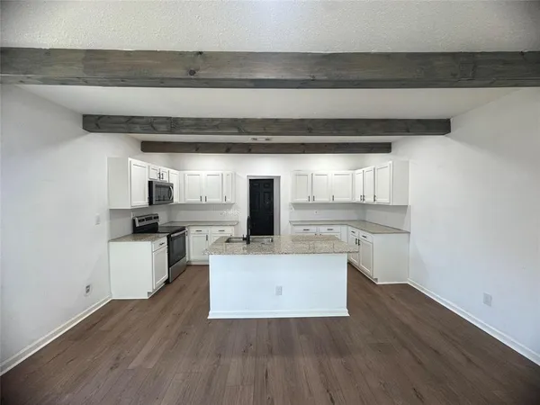 a view of living room with stainless steel appliances wooden floor and view living room