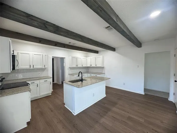 a kitchen with a sink cabinets and wooden floor