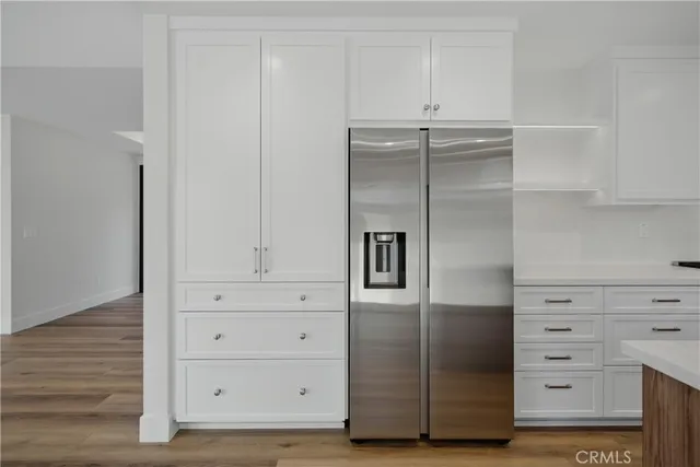 a kitchen with white cabinets and a window