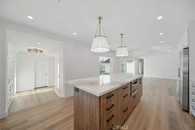 a kitchen with white cabinets and a stove with wooden floor