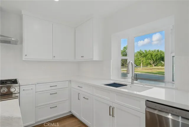 a view of kitchen with wooden floor and electronic appliances
