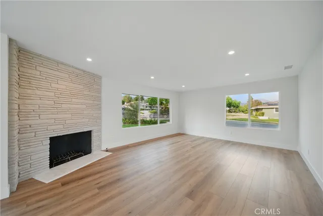 an empty room with wooden floor and fireplace
