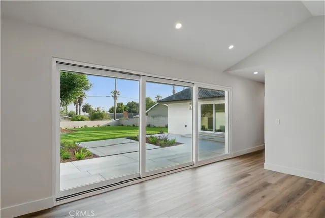 a view of an empty room with wooden floor and closet