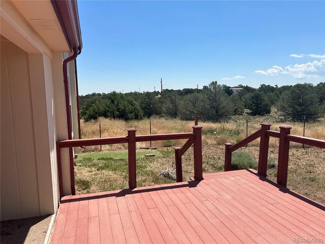 a view of a balcony with chairs and wooden floor