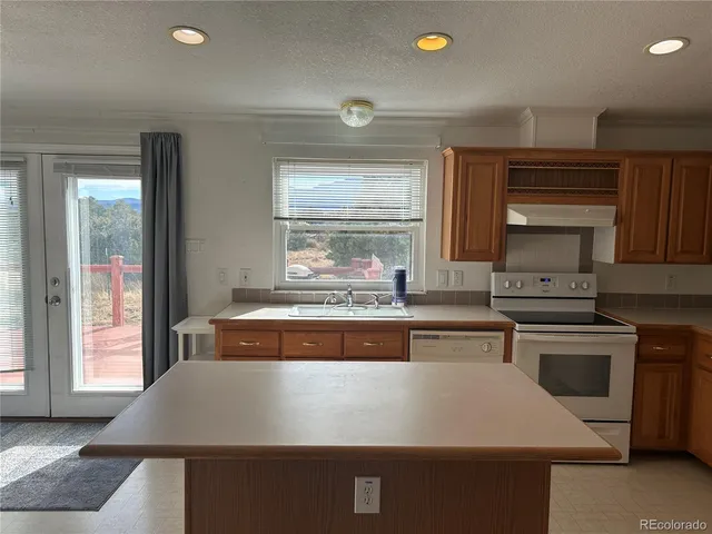 a kitchen with kitchen island sink and window