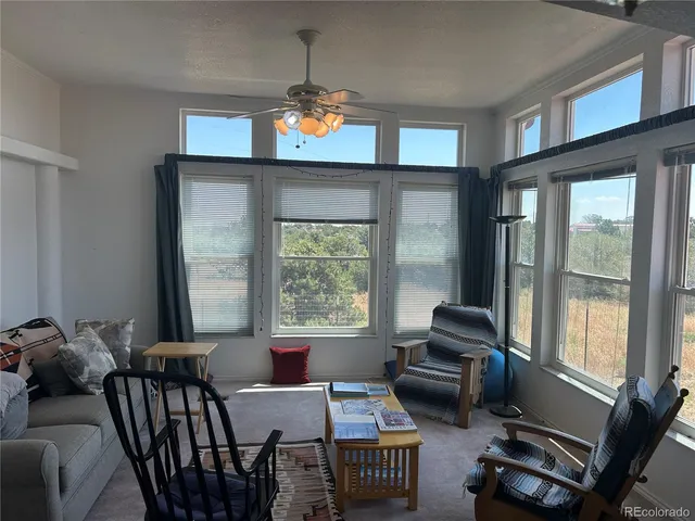 a living room with furniture and two windows