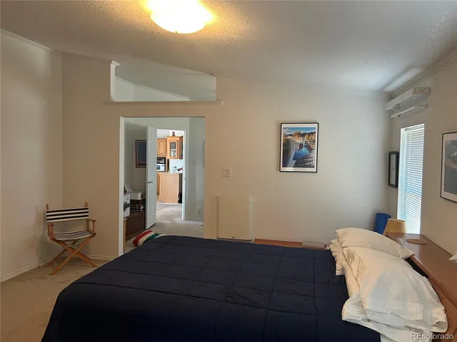 a bedroom with a bed and a lamp on the dresser