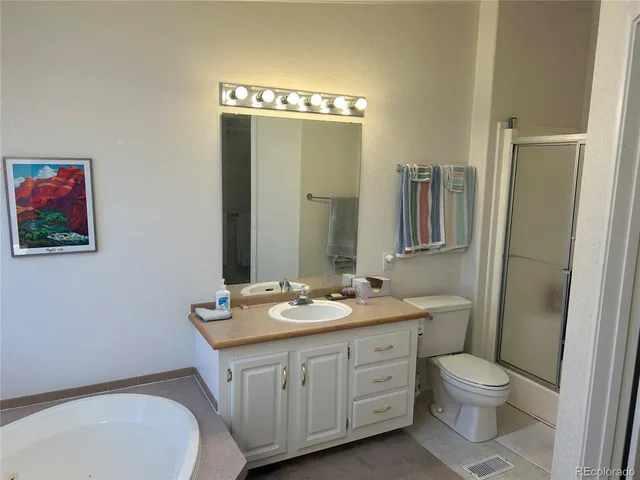 a bathroom with a double vanity sink toilet mirror and shower