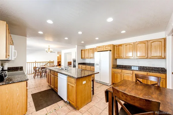 a utility room with granite countertop cabinets and a sink