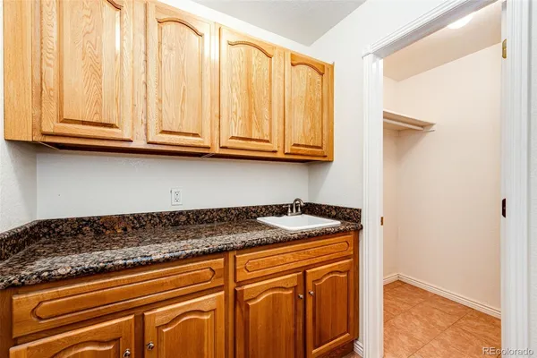 a dining hall with stainless steel appliances granite countertop a stove a sink a dining table and chairs