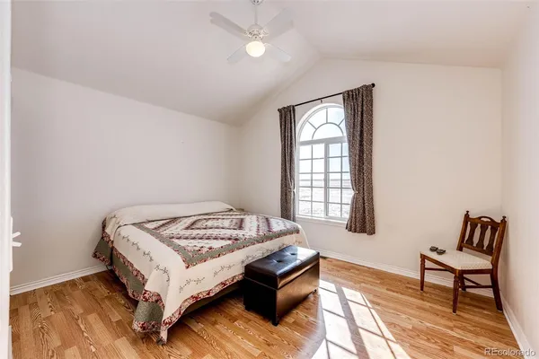 a view of a bedroom with a bed and wooden floor