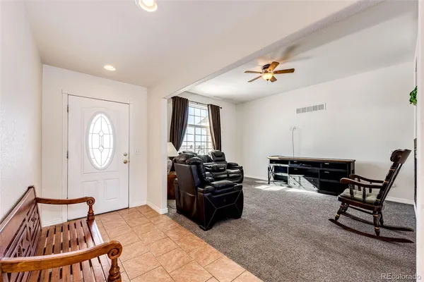 a living room with furniture a air conditioner vent and a window