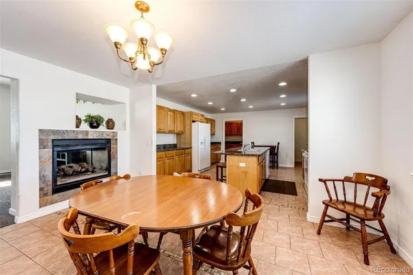 a kitchen with stainless steel appliances granite countertop a stove top oven a sink dishwasher and a refrigerator with wooden cabinets