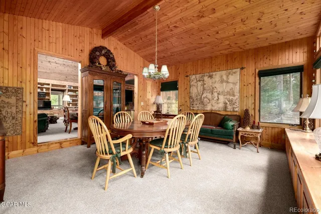 a dining room with furniture and large windows