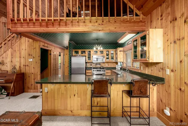 a kitchen with stainless steel appliances granite countertop a refrigerator and a stove