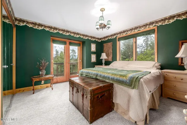 a bedroom with a large bed and a chandelier