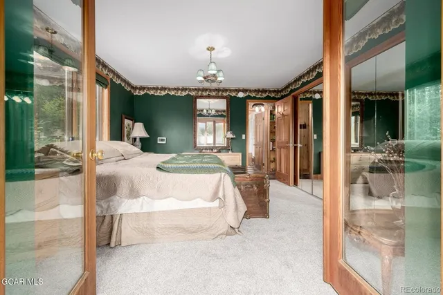a spacious bedroom with a large bed and a chandelier