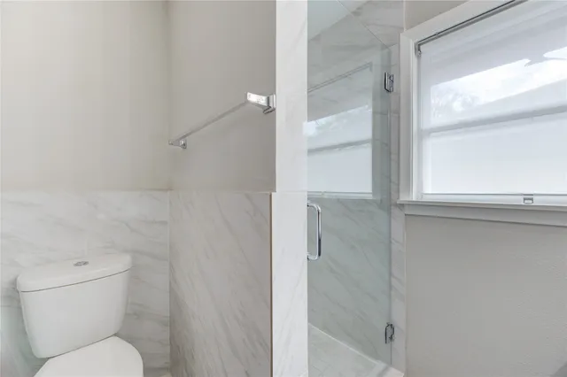 a bathroom with a toilet and a shower