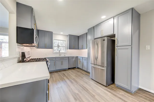 a kitchen with stainless steel appliances a refrigerator and a stove top oven