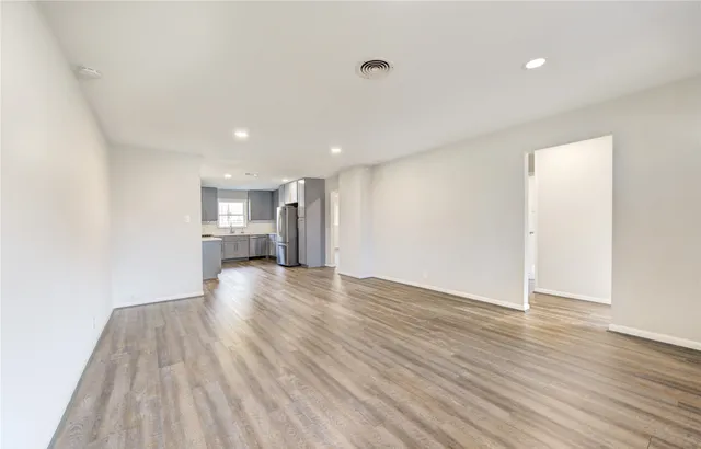 a view of empty room with wooden floor