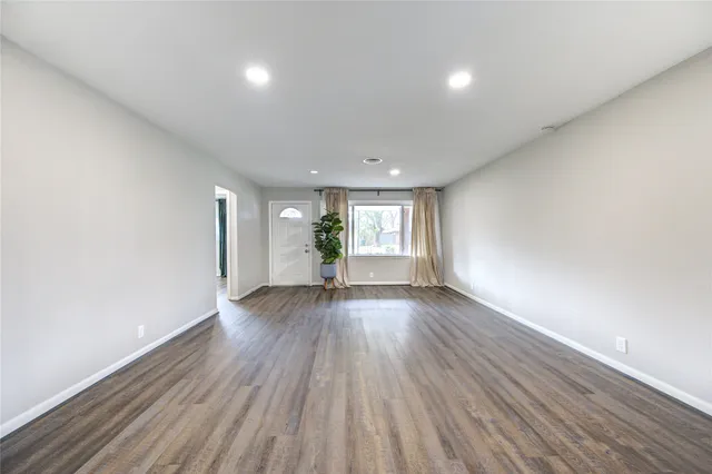 a view of a big room with wooden floor and windows