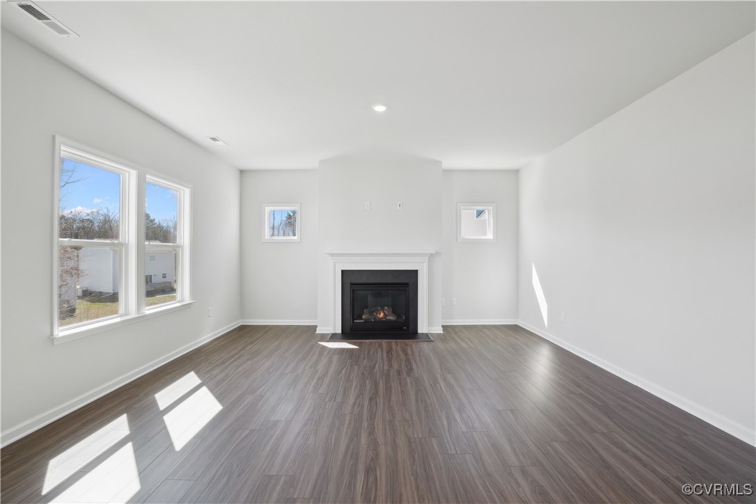 229 Bellevue Circle Aylett, VA 23009 - Photo 6 of 18 a view of an empty room with wooden floor fireplace and a window