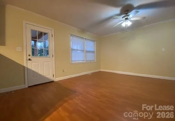 an empty room with windows and fan