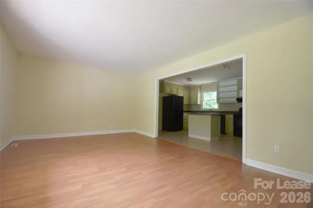 a view of an empty room with a kitchen