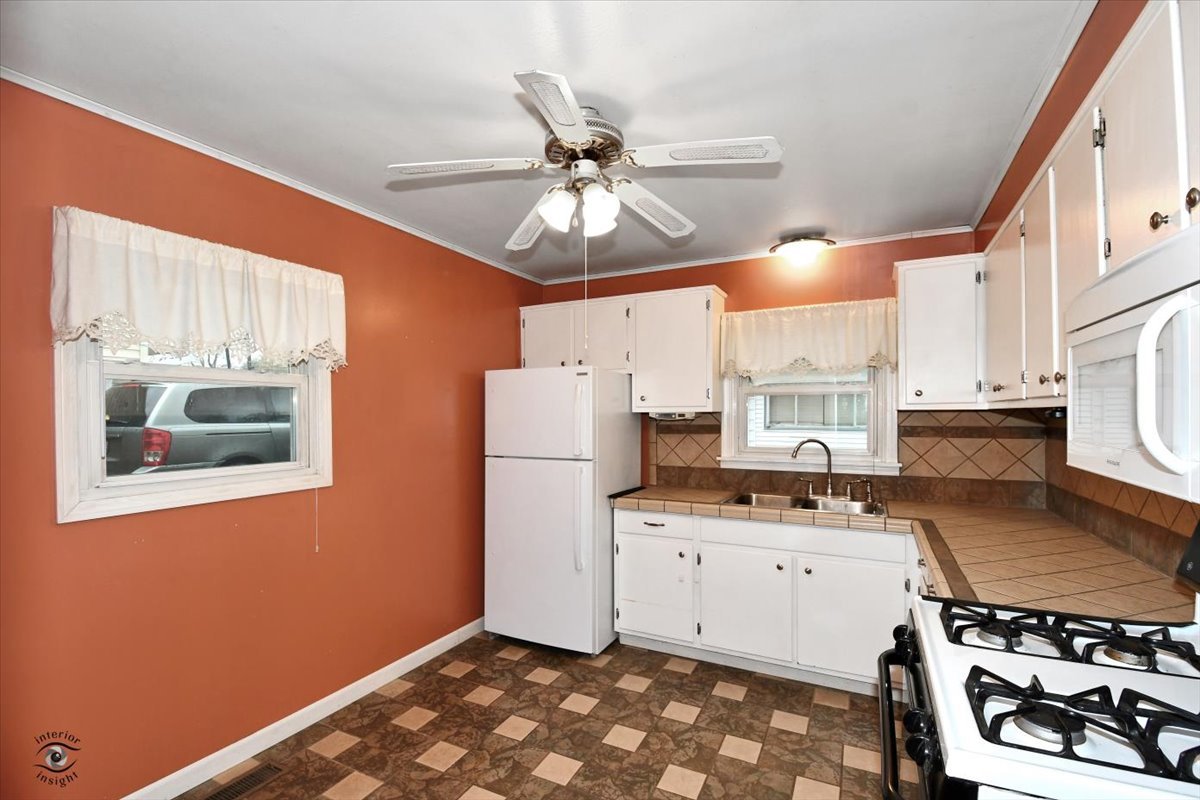 160 Monee Road Park Forest, IL 60466 - Photo 7 of 24 a kitchen with a stove a refrigerator and a sink
