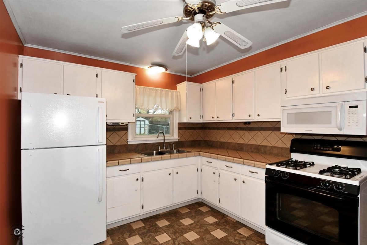 160 Monee Road Park Forest, IL 60466 - Photo 8 of 24 a kitchen with granite countertop a white cabinets and white appliances