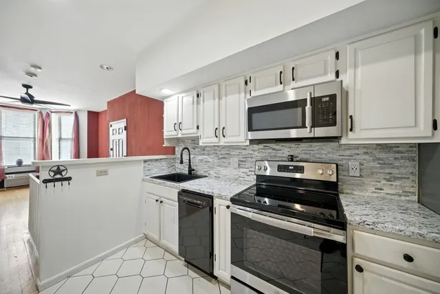 a kitchen with stainless steel appliances granite countertop a stove microwave and cabinets