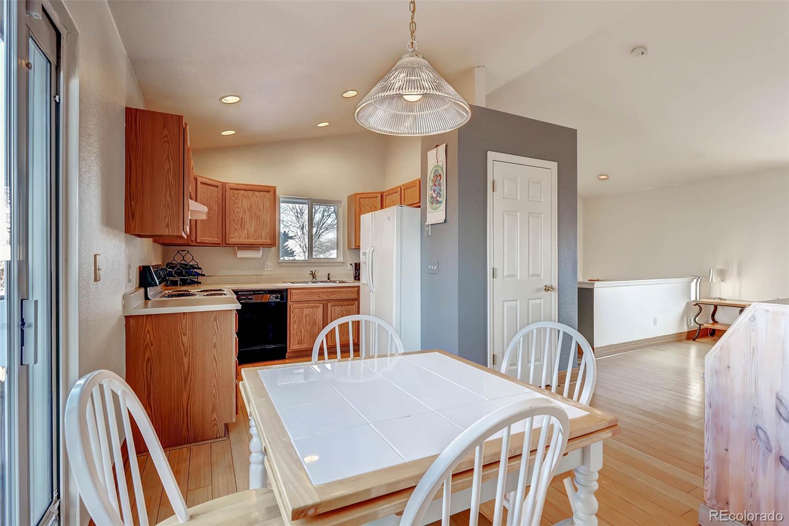 965 Wolff Street, Unit A Denver, CO 80204 - Photo 7 of 34 a kitchen with stainless steel appliances granite countertop a table chairs and a refrigerator