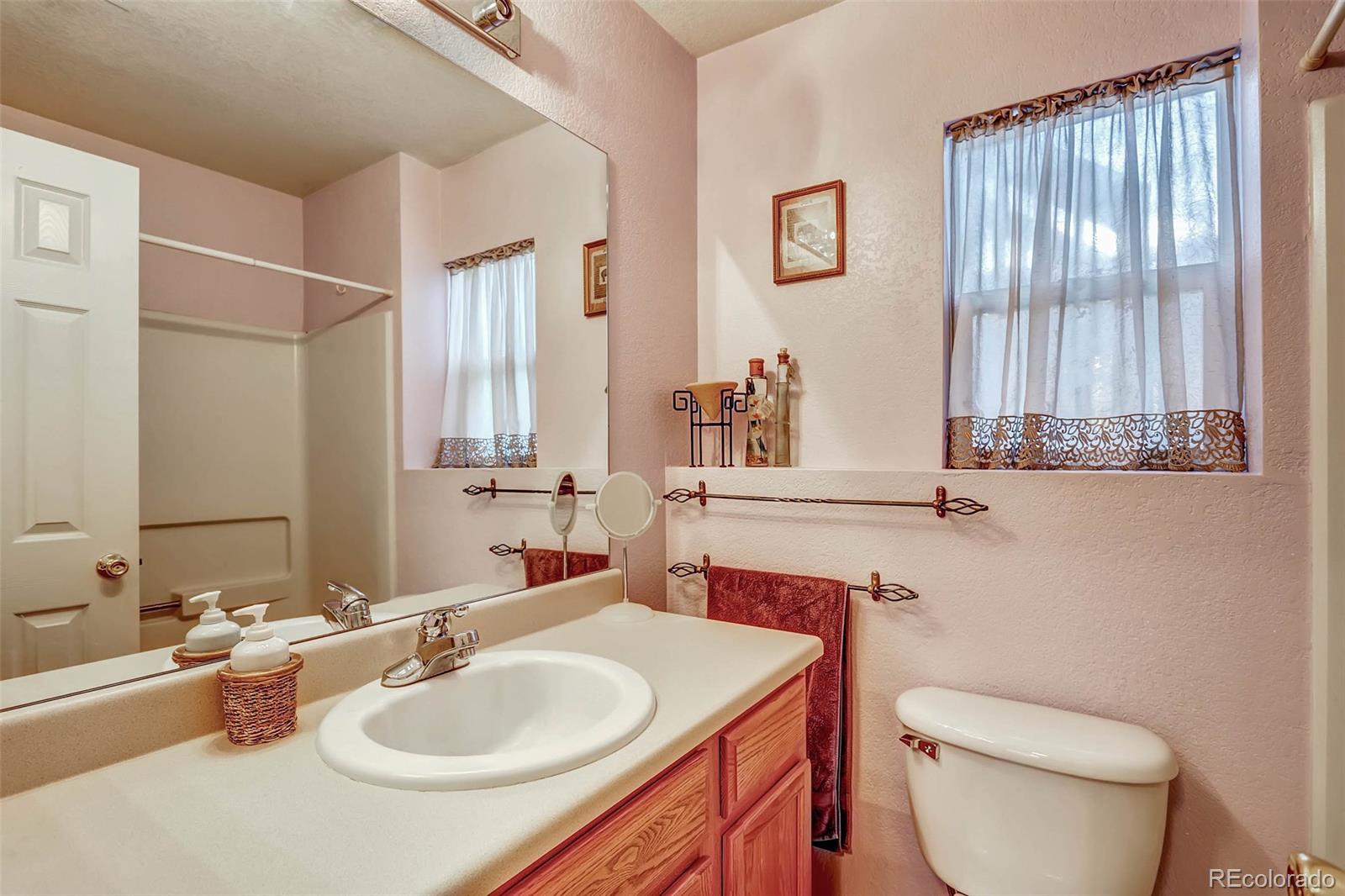 965 Wolff Street, Unit A Denver, CO 80204 - Photo 8 of 34 a bathroom with a toilet sink and mirror