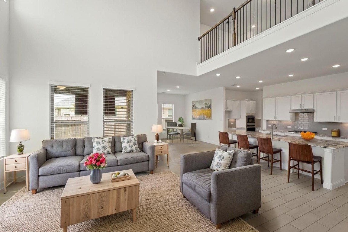 8010 Chantilly Manor Fulshear, TX 77441 - Photo 14 of 50 Experience modern living in this stunning, open-concept space featuring a spacious living area, elegant kitchen with a breakfast bar, and abundant natural light. Perfect for entertaining and everyday comfort.