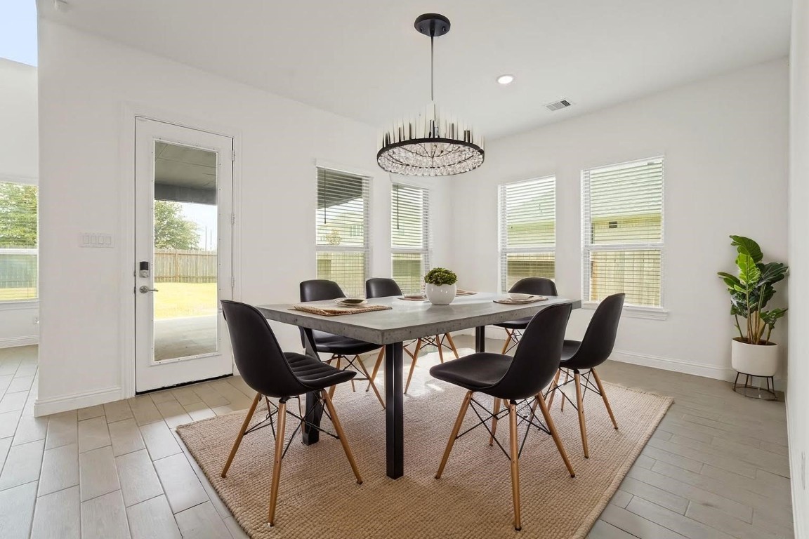 8010 Chantilly Manor Fulshear, TX 77441 - Photo 19 of 50 Experience modern elegance in this beautifully staged dining area, featuring abundant natural light, chic furnishings, and a seamless connection to the outdoor space. Perfect for stylish entertaining or intimate family meals.