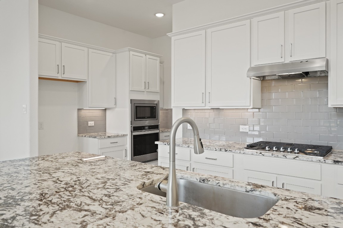 8010 Chantilly Manor Fulshear, TX 77441 - Photo 21 of 50 Third view of the kitchen showcasing sleek stainless steel appliances, recessed lighting, and a modern, open layout that blends style and functionality