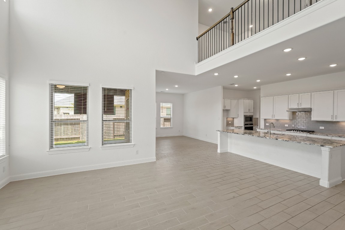 8010 Chantilly Manor Fulshear, TX 77441 - Photo 23 of 50 Open-to-below view enhances the open-concept design, creating a bright and airy atmosphere that connects the main living areas with the upper level.
