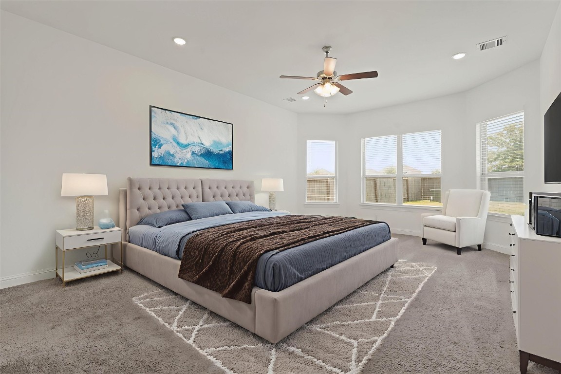 8010 Chantilly Manor Fulshear, TX 77441 - Photo 27 of 50 Spacious master bedroom with abundant natural light, featuring a cozy seating area and a stylish, modern design.