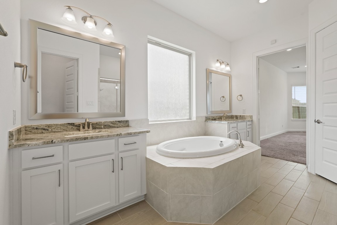 8010 Chantilly Manor Fulshear, TX 77441 - Photo 30 of 50 The primary bathroom features a jetted tub, a stand-up shower, and a dual vanity for added convenience and luxury