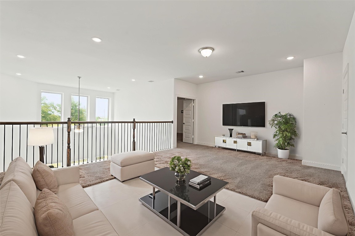 8010 Chantilly Manor Fulshear, TX 77441 - Photo 33 of 50 Spacious and bright living area with modern virtual staging. Features a sleek entertainment setup, cozy seating, and abundant natural light from large windows. Perfect for relaxation and entertainment.