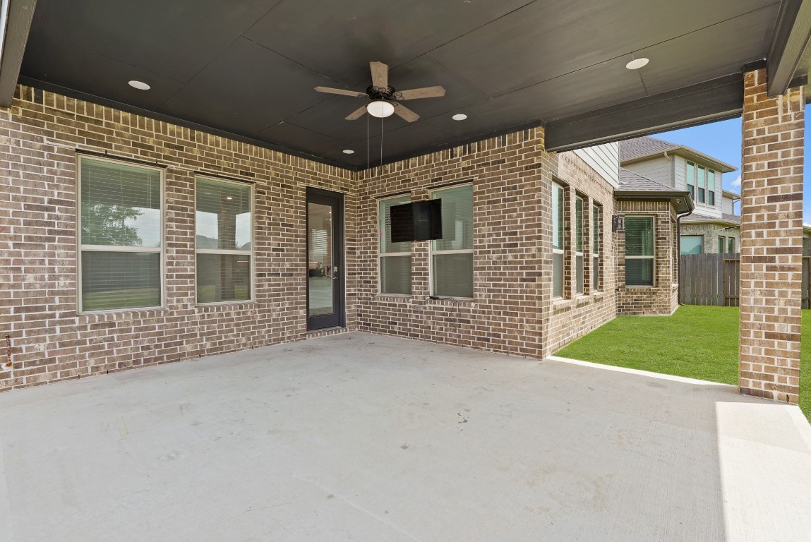 8010 Chantilly Manor Fulshear, TX 77441 - Photo 44 of 50 The extended covered patio features a ceiling fan and a mounted TV, creating the perfect space for outdoor relaxation and entertainment