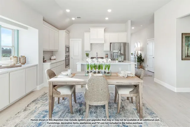 a kitchen with a dining table chairs appliances and cabinets
