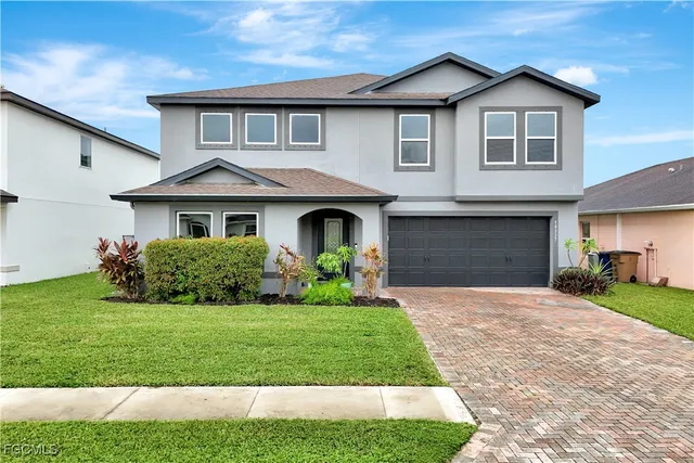 a front view of a house with a yard and garage