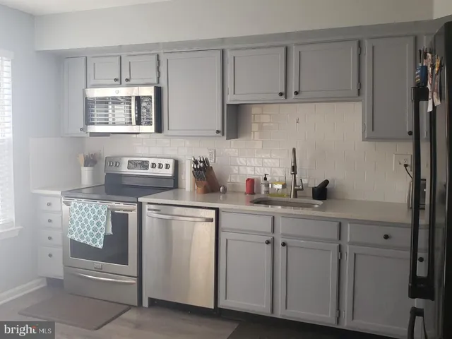 a kitchen with white cabinets and white appliances