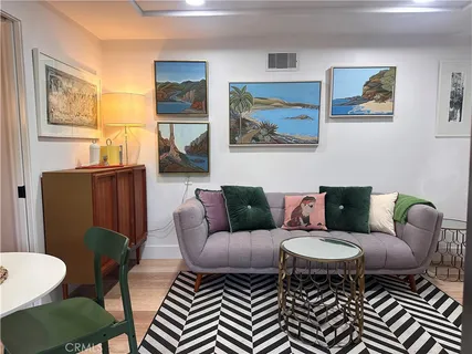 a living room with furniture a couch and paintings on the wall