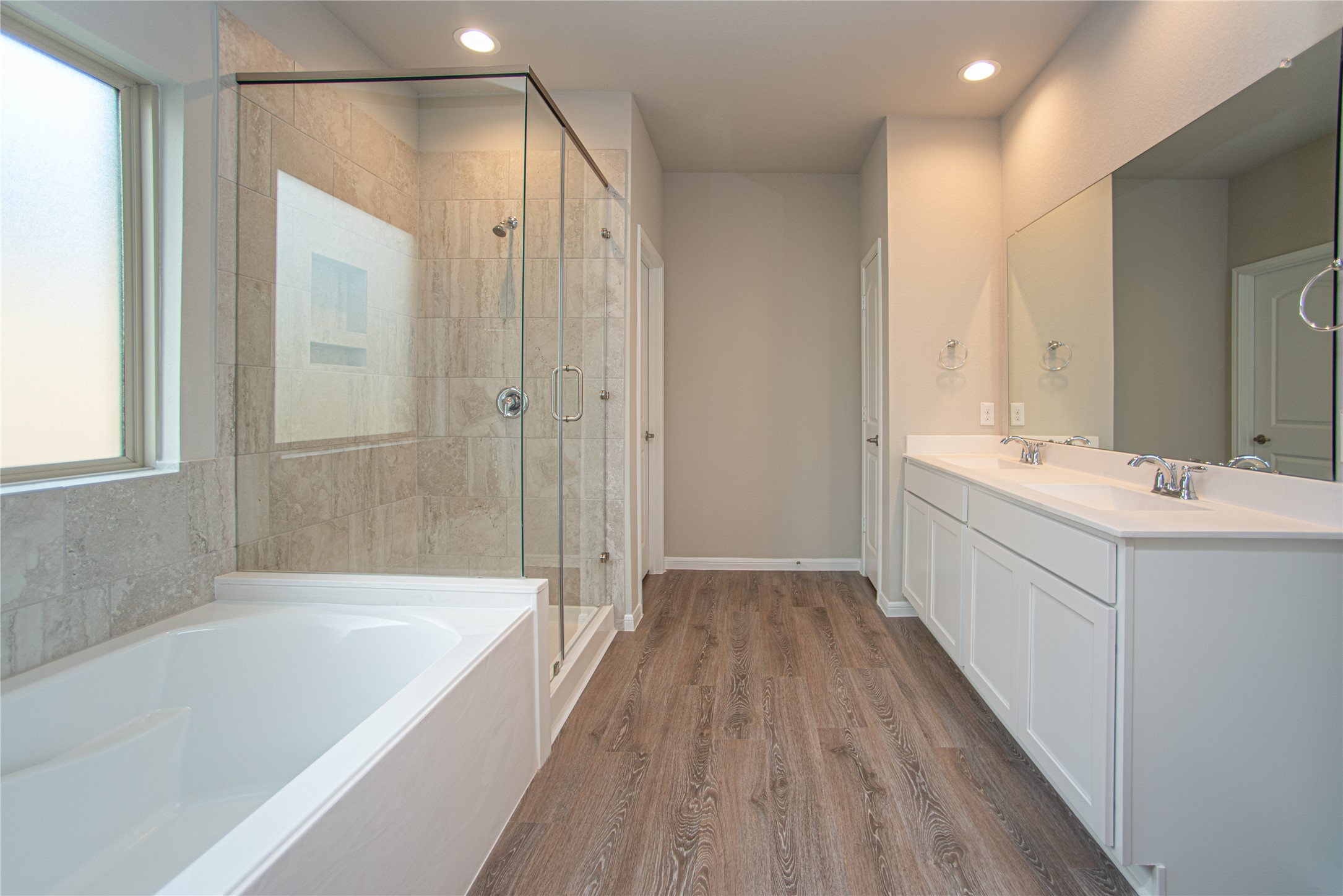 439 Stonebrook Lane Conroe, TX 77304 - Photo 11 of 19 a bathroom with a double vanity sink a mirror and a bathtub
