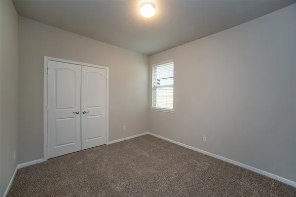 an empty room with windows and closet